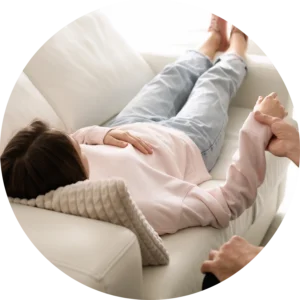 kobieta na kanapie leży ktoś trzyma ją za rękę