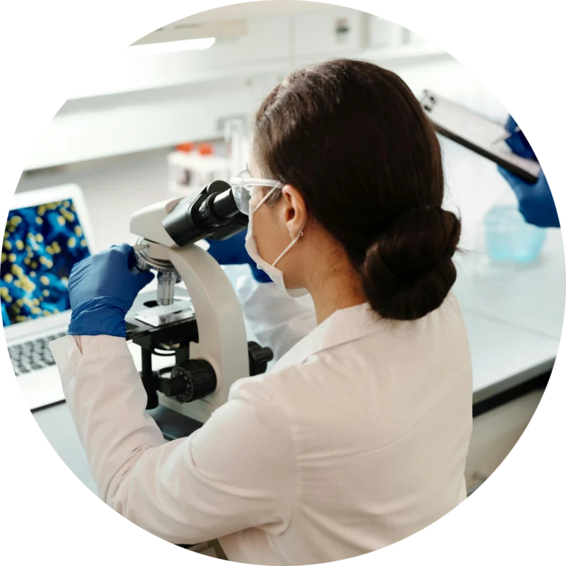 Wymaz-cytologiczny-–-co-to-za-badanie-i-dlaczego-jest-ważne kobieta w białym fartuchu przy mikroskopie