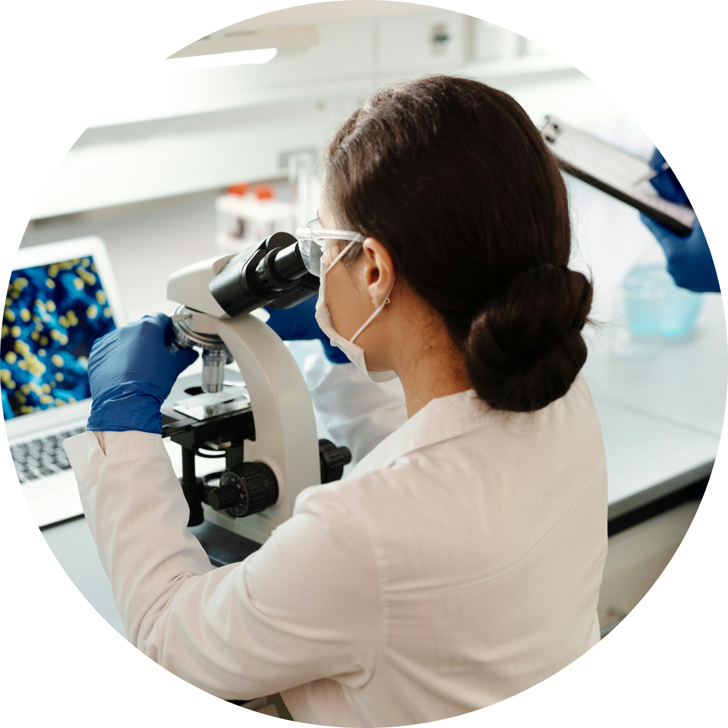 kobieta w białym fartuchu przy mikroskopie